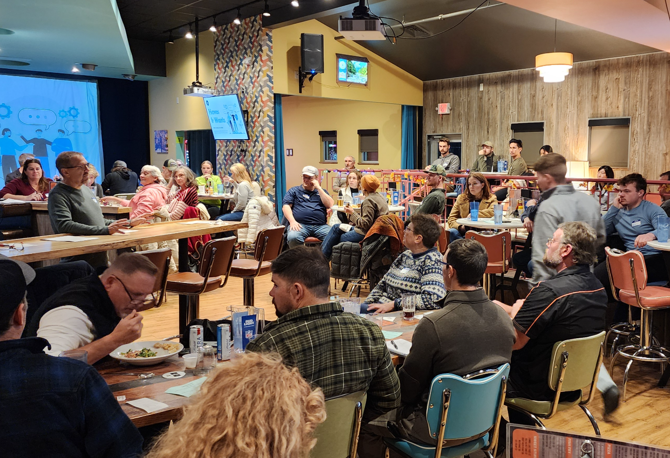 People seated around tables listening to a speaker at a real estate gathering